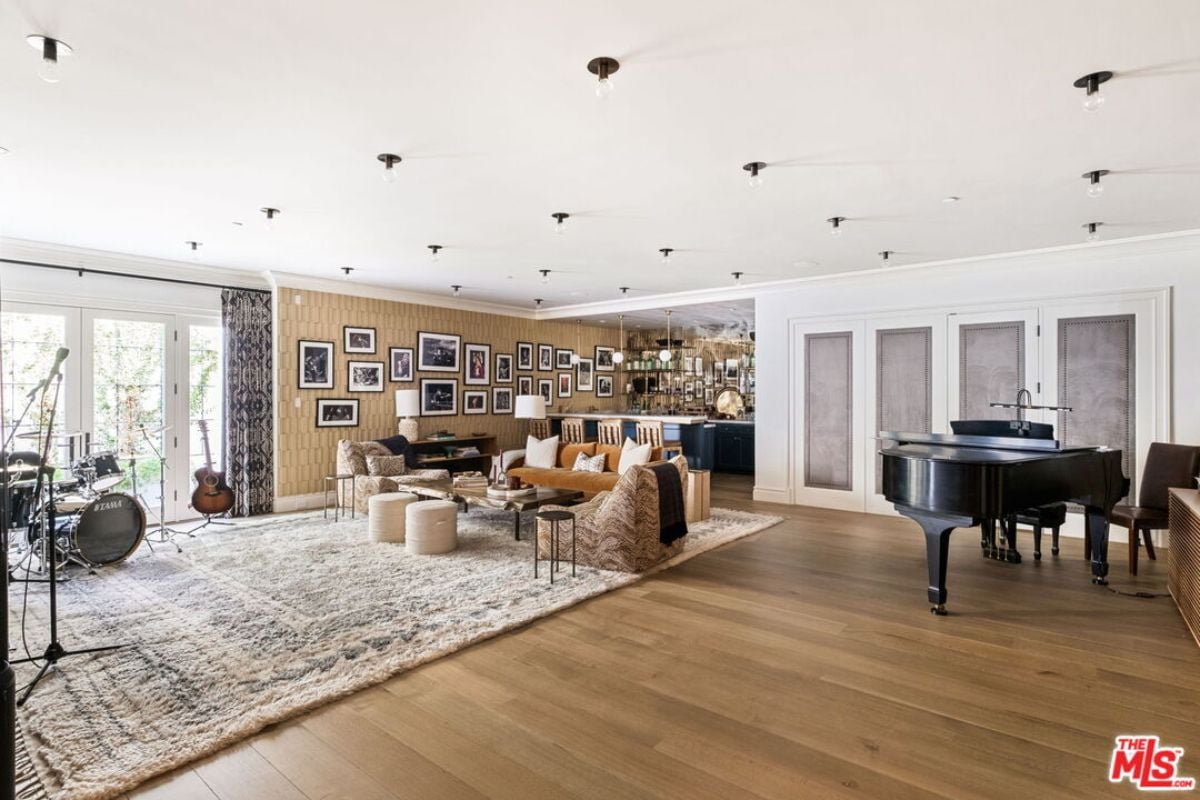 The music room is equipped with a drum set, piano, living space, and a bar.