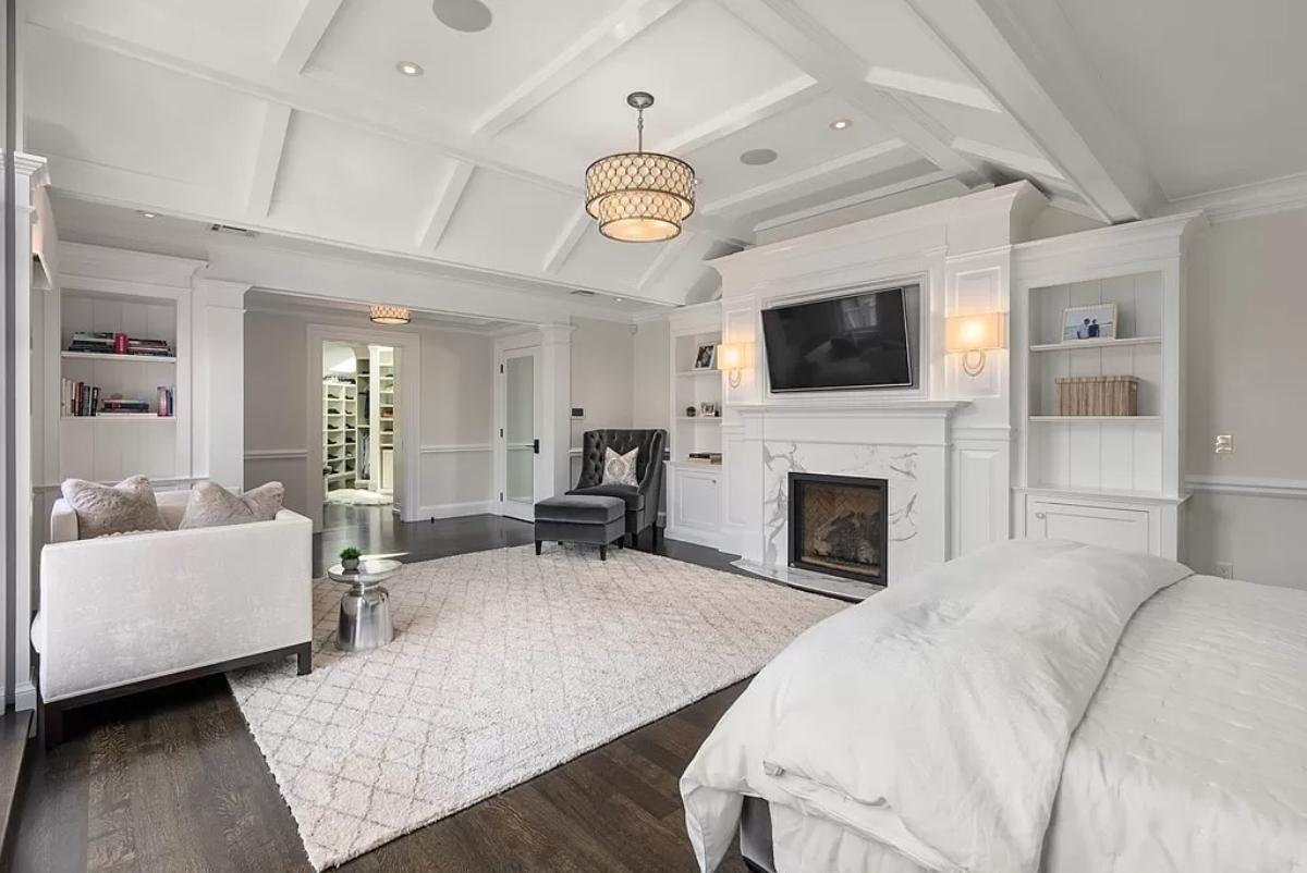 Bedroom with hardwood floors and a fireplace.