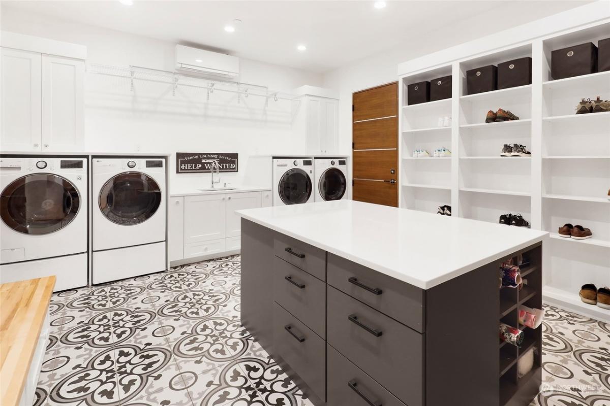 Laundry room with an island and shelves.