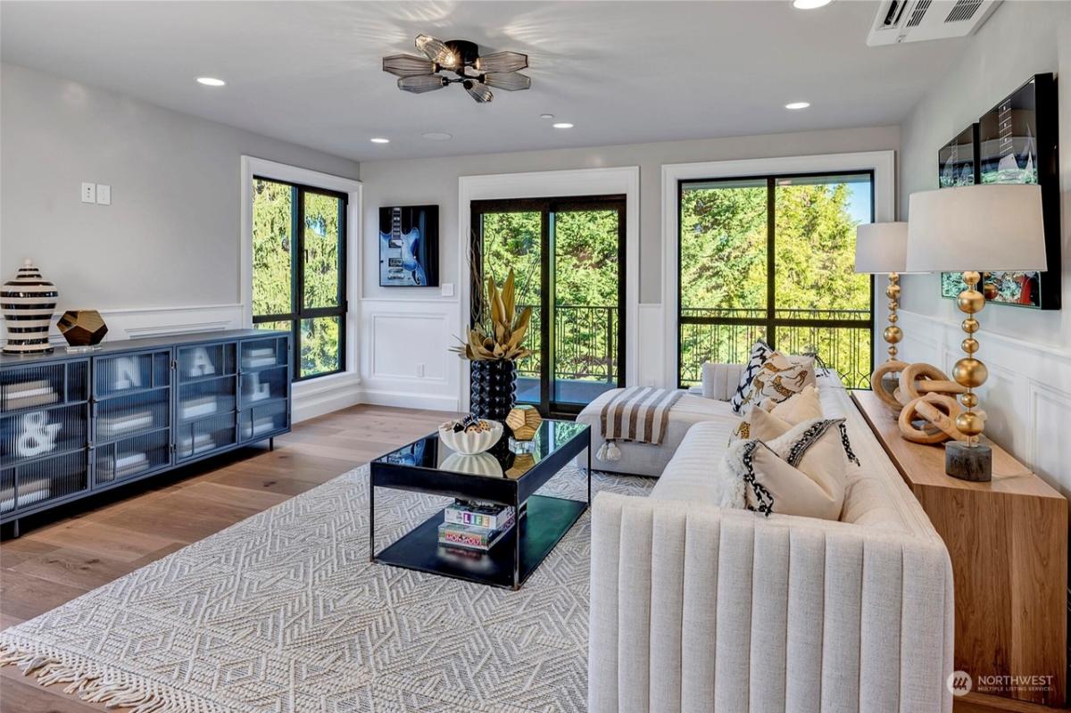 Living space with hardwood floors, glass windows and glass doors.