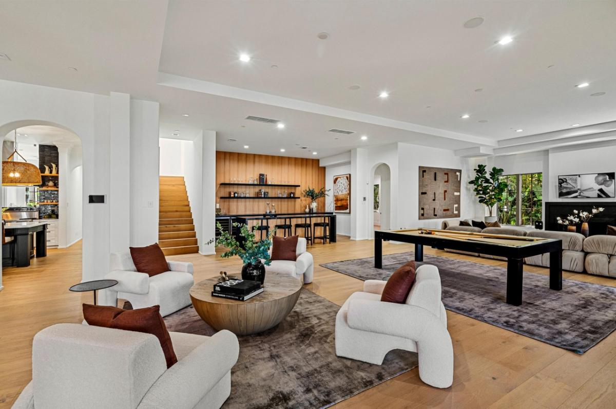 Recreational room with a billiards table, couches and a bar.