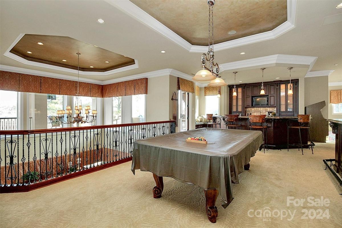 Recreational room with a billiards table and a bar.