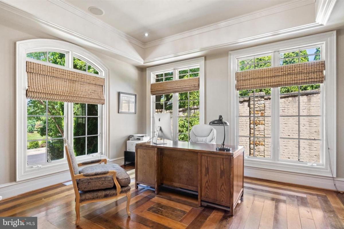 Home office with hardwood floors and glass windows.