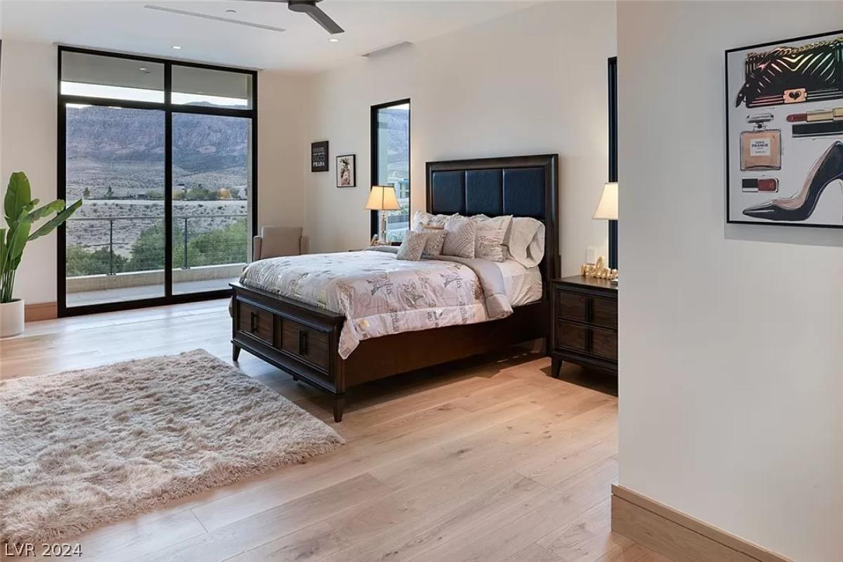 Bedroom with hardwood flooring and sliding glass doors.