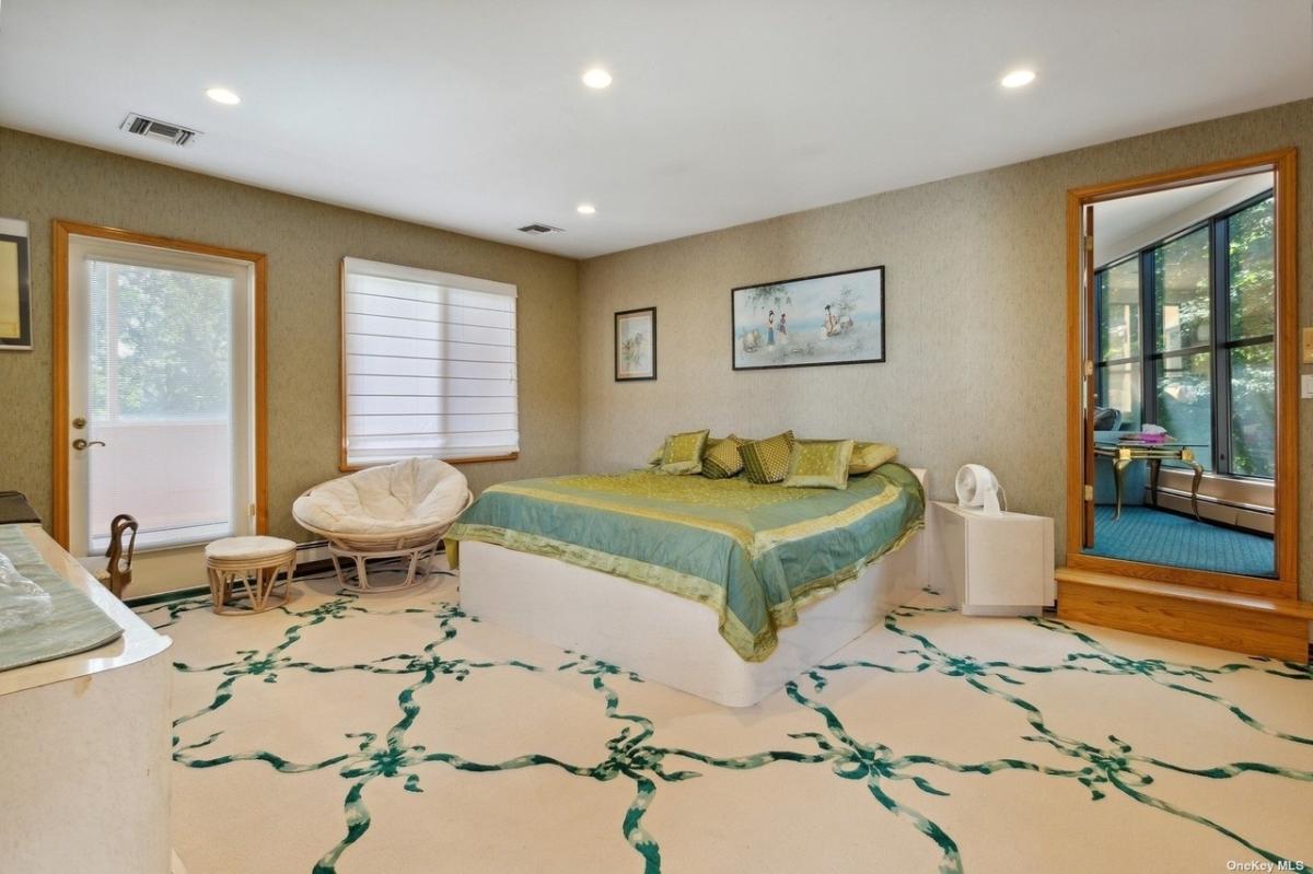 Bedroom with carpet flooring and a large bed.