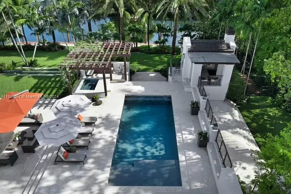 Pool with lounge chairs and a pergola.