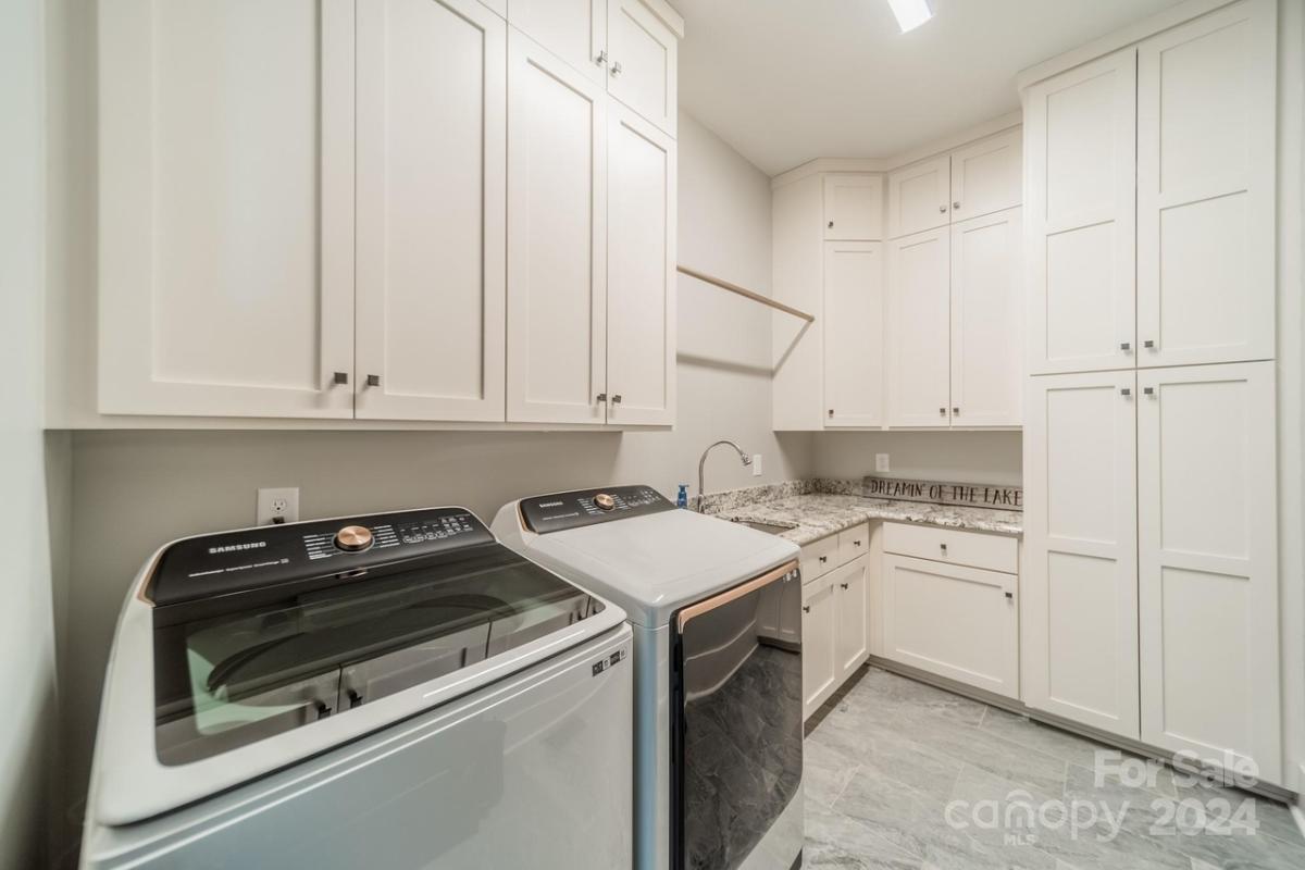 Laundry room with a sink and cabinets.