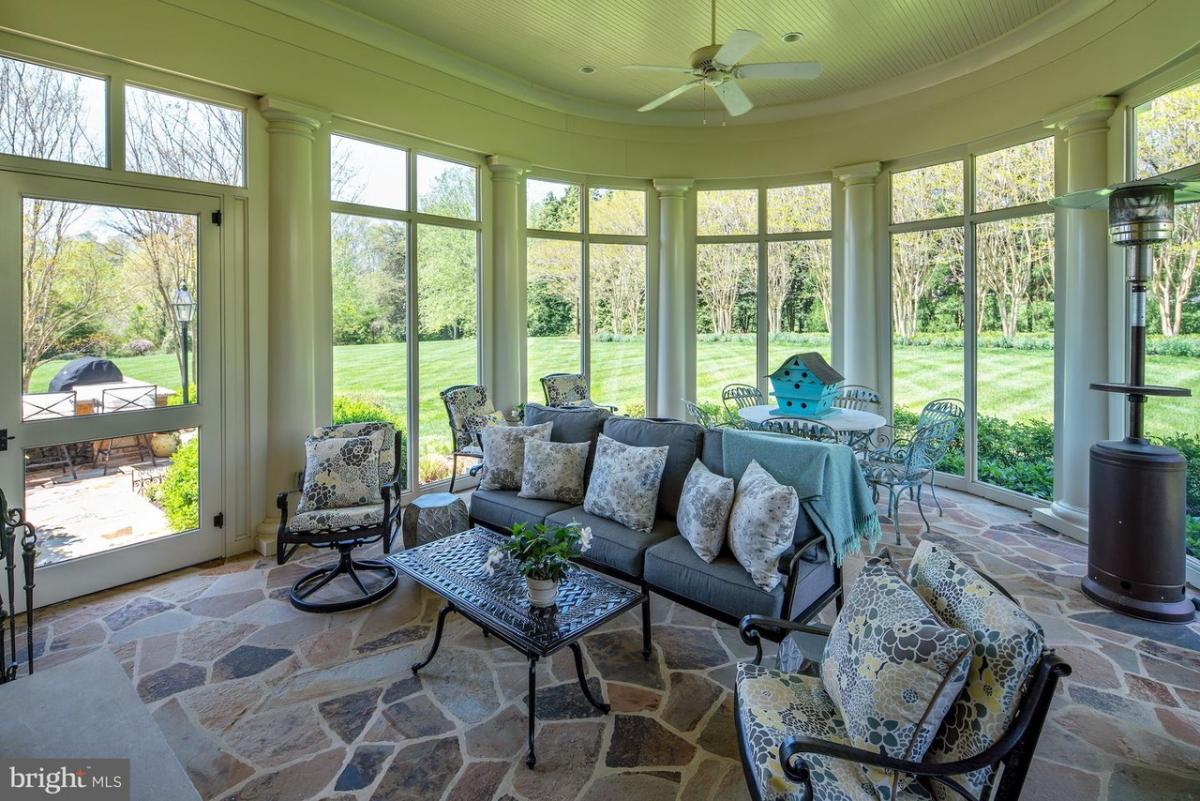 Sunroom with couches and glass windows.