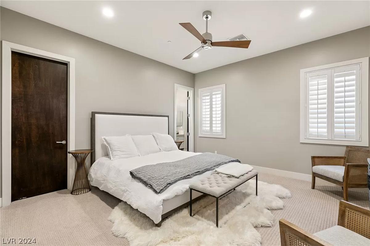 Bedroom with carpet flooring and a large bed.