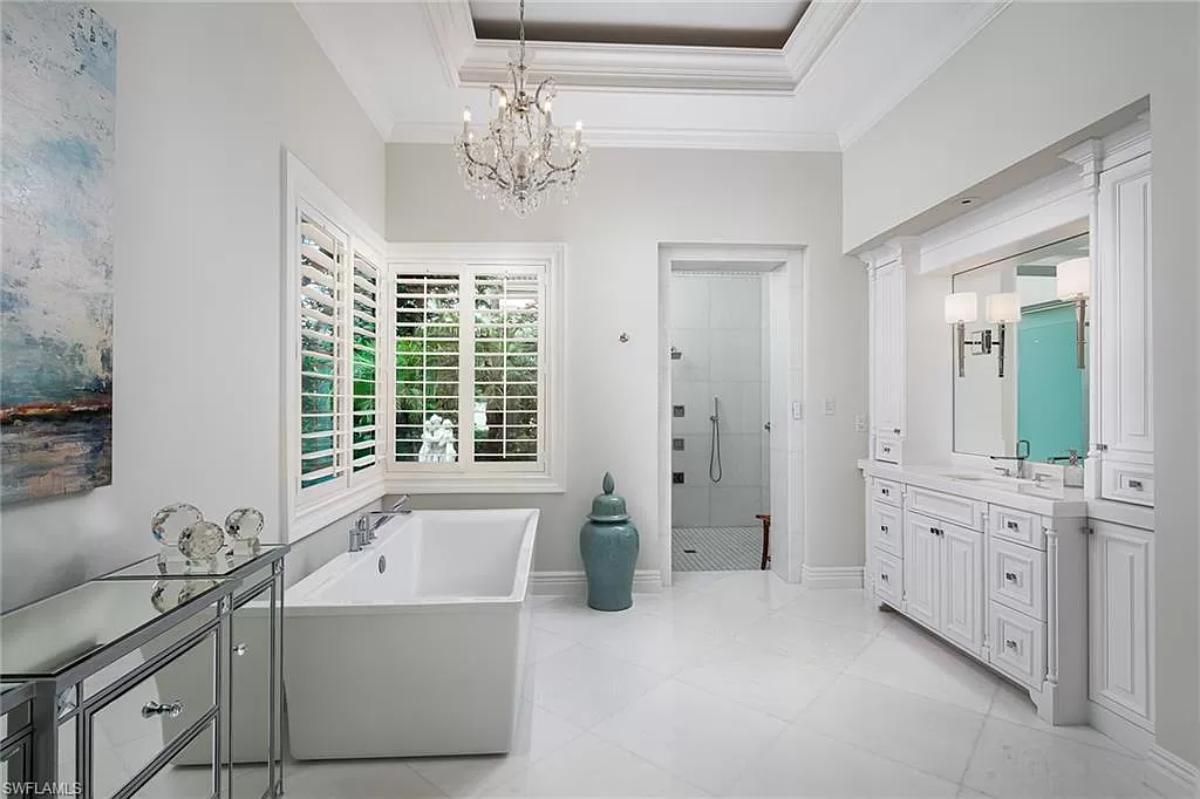 Bathroom with a chandelier, soaking tub and a walk-in shower.