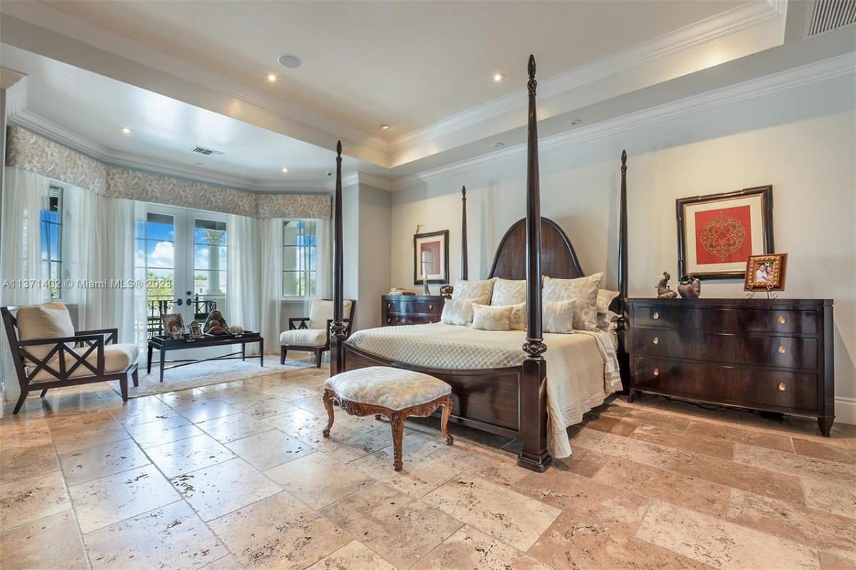 Bedroom with a large bed and marble flooring.