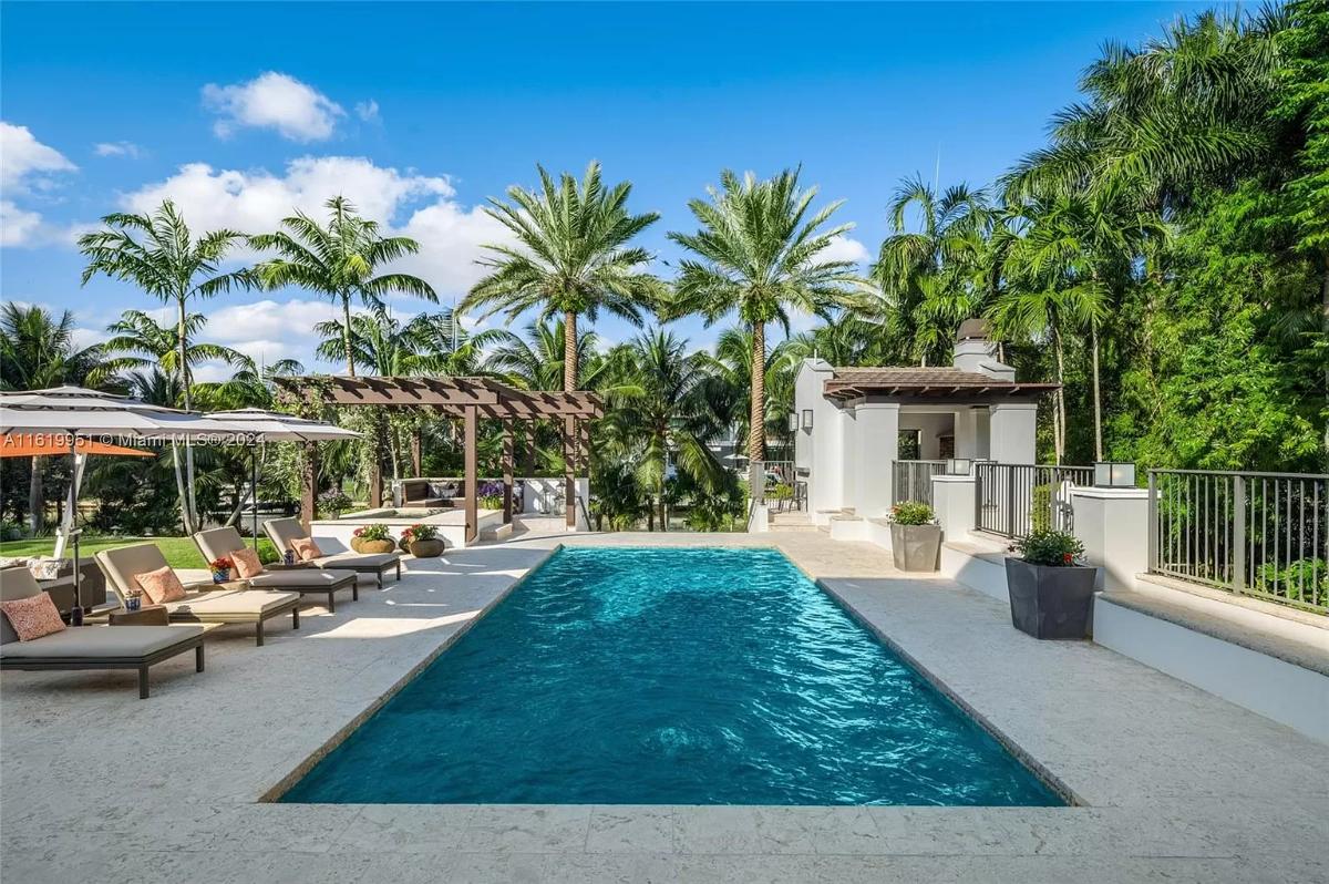 Pool with lounge chairs and a pergola.