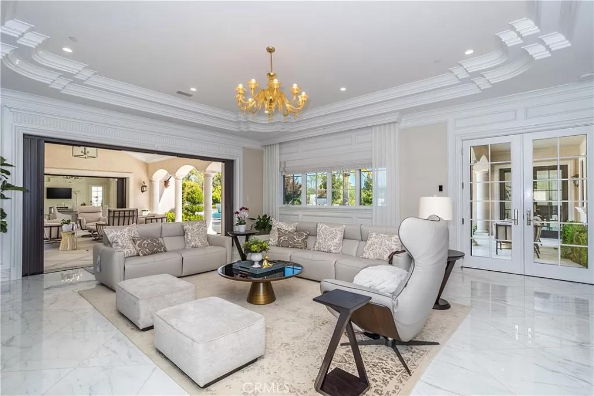Living room with a chandelier and coffered ceilings.
