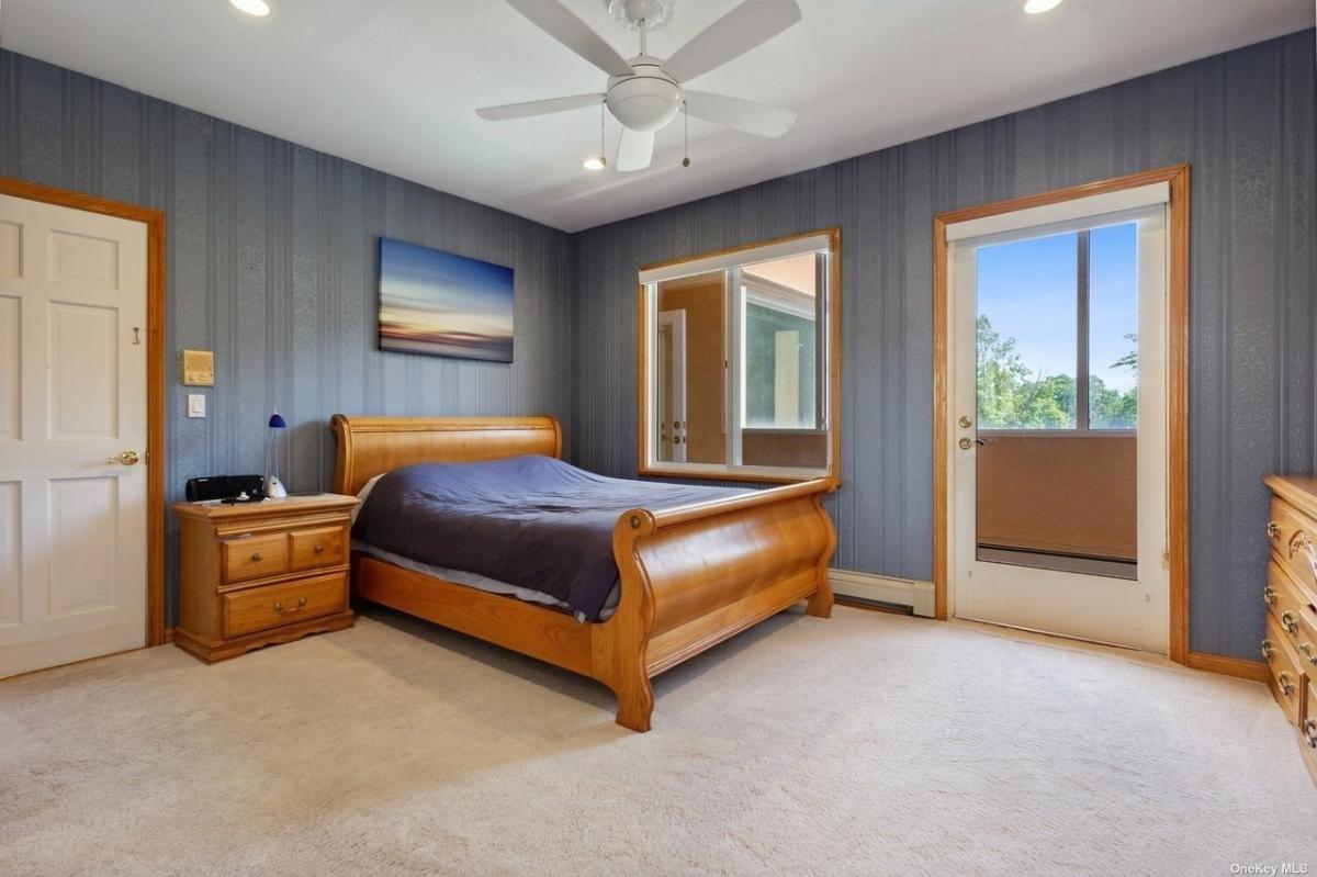Bedroom with carpet flooring and a large bed.