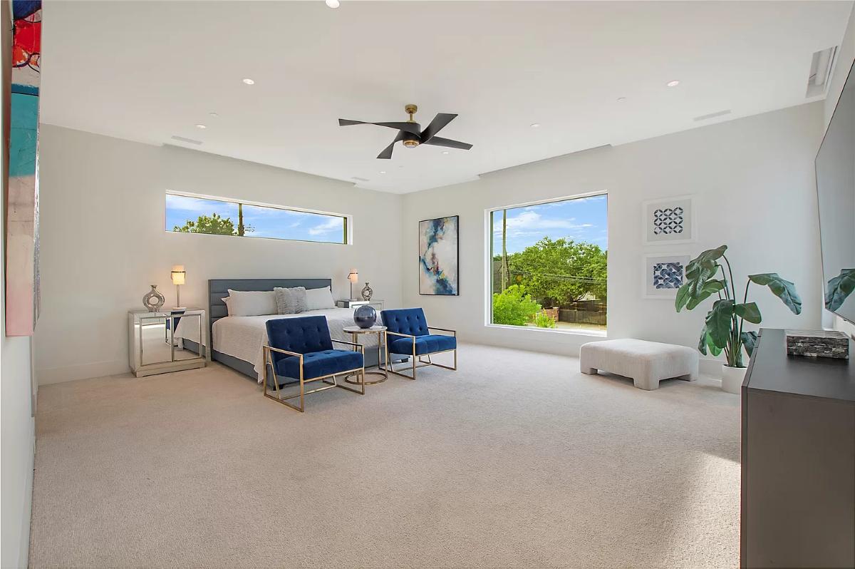 Bedroom with carpet flooring and glass windows..