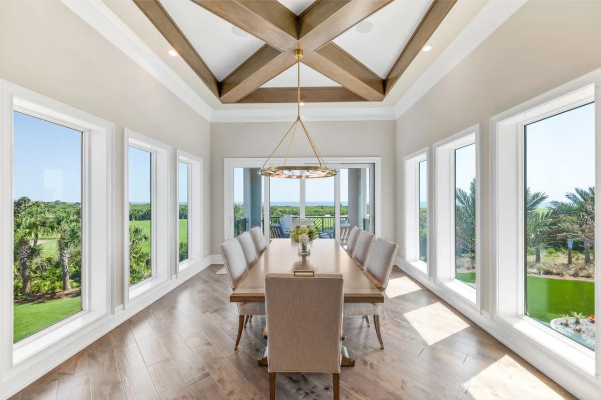 Dining room with a chandelier and glass walls.