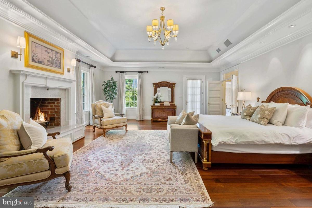 Bedroom with a fireplace and hardwood flooring.