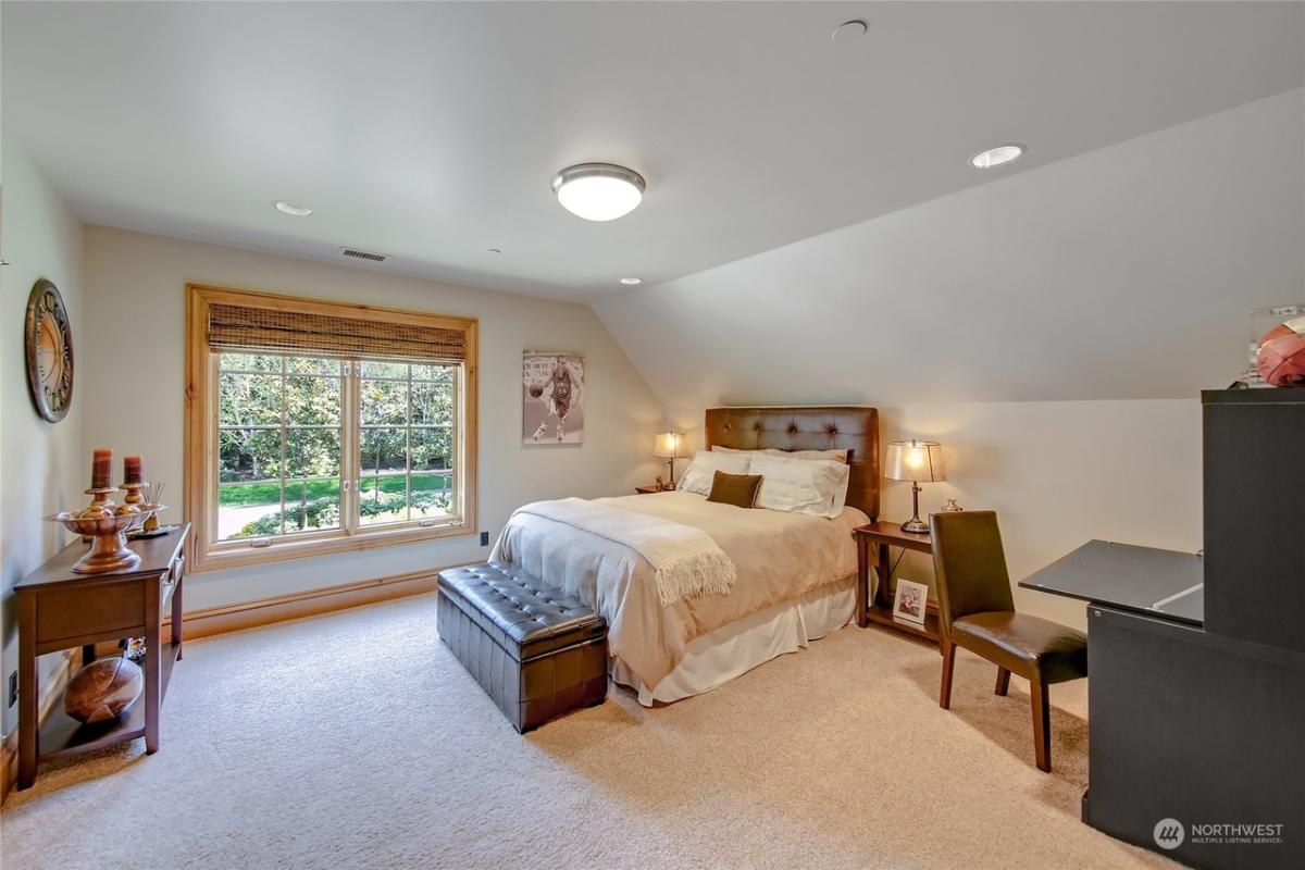 Bedroom with a large bed and carpet flooring.
