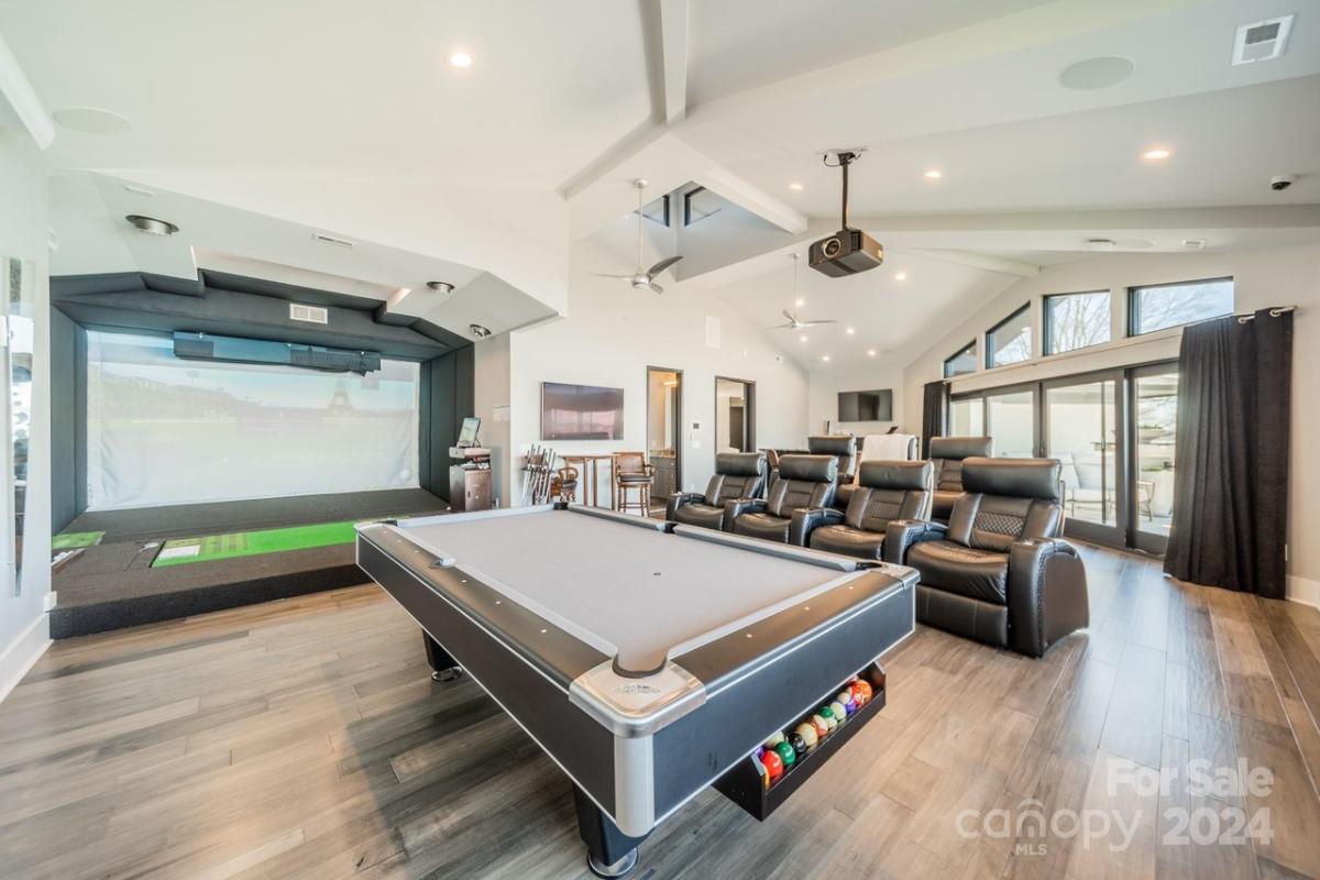 Recreational room with a billiards table, golf simulator and home theater.