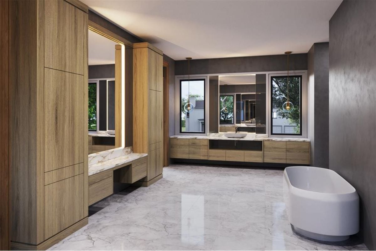 A bathroom with a vanity, mirrors, cabinets, a tiled floor, and a bathtub.