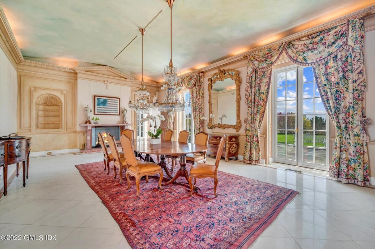 Dining room with a fireplace and chandeliers.