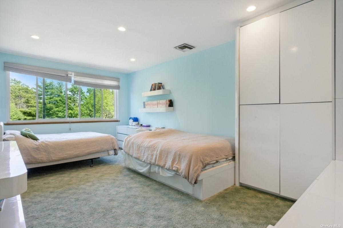 Bedroom with carpet flooring and glass windows.