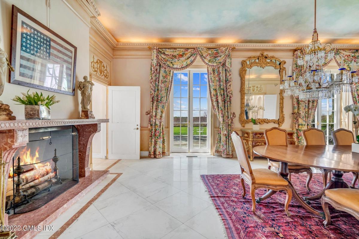 Dining room with a fireplace and chandeliers.