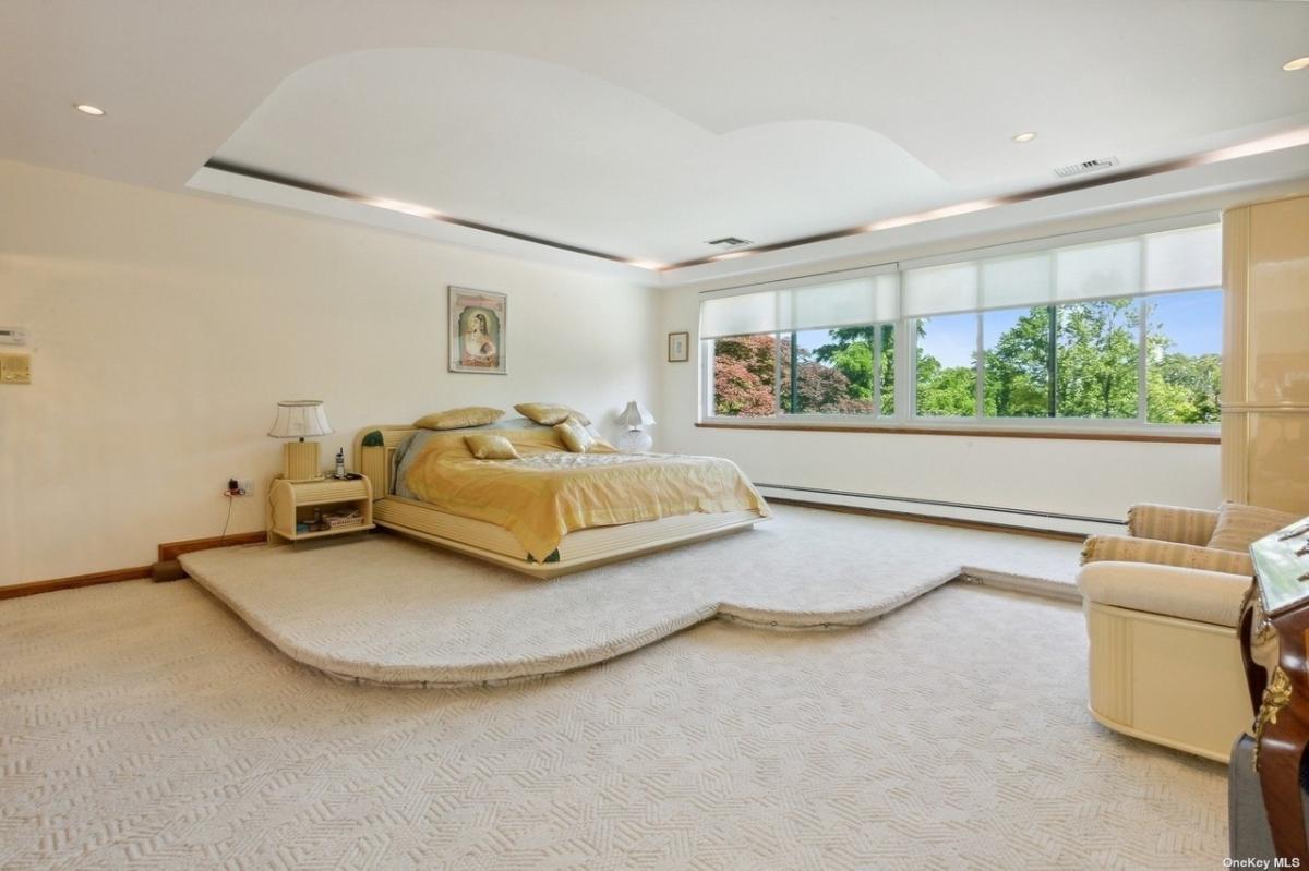 Bedroom with carpet flooring and glass windows.