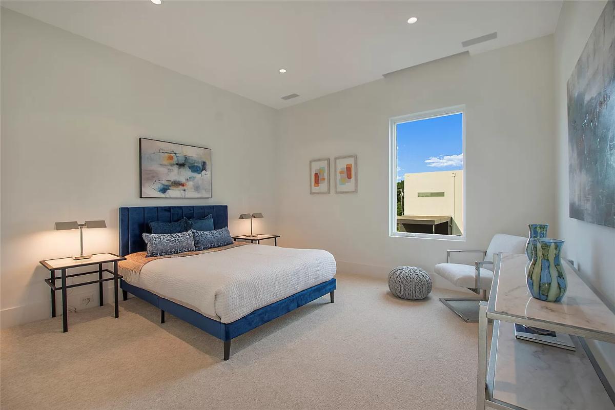 Bedroom with carpet flooring and glass windows.