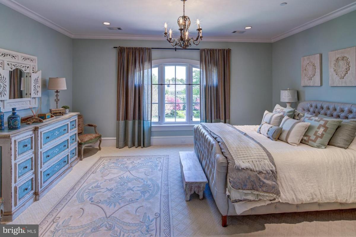 Bedroom with carpet flooring and a chandelier.