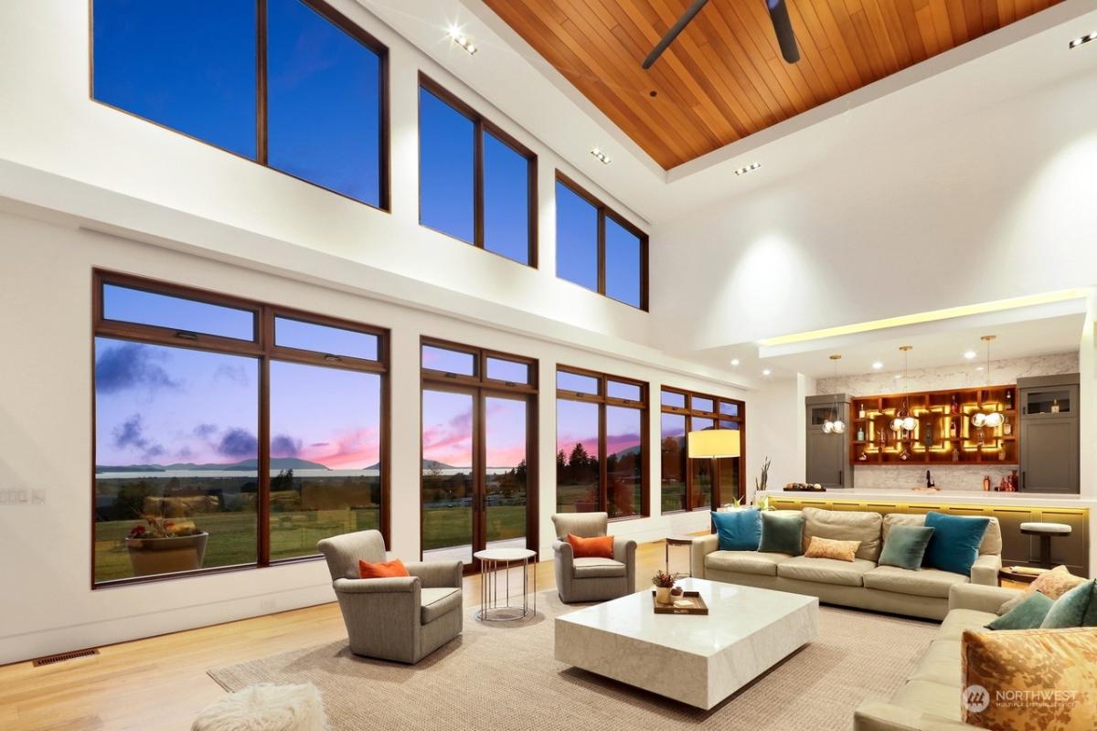 Living room with couches and a huge glass windows.