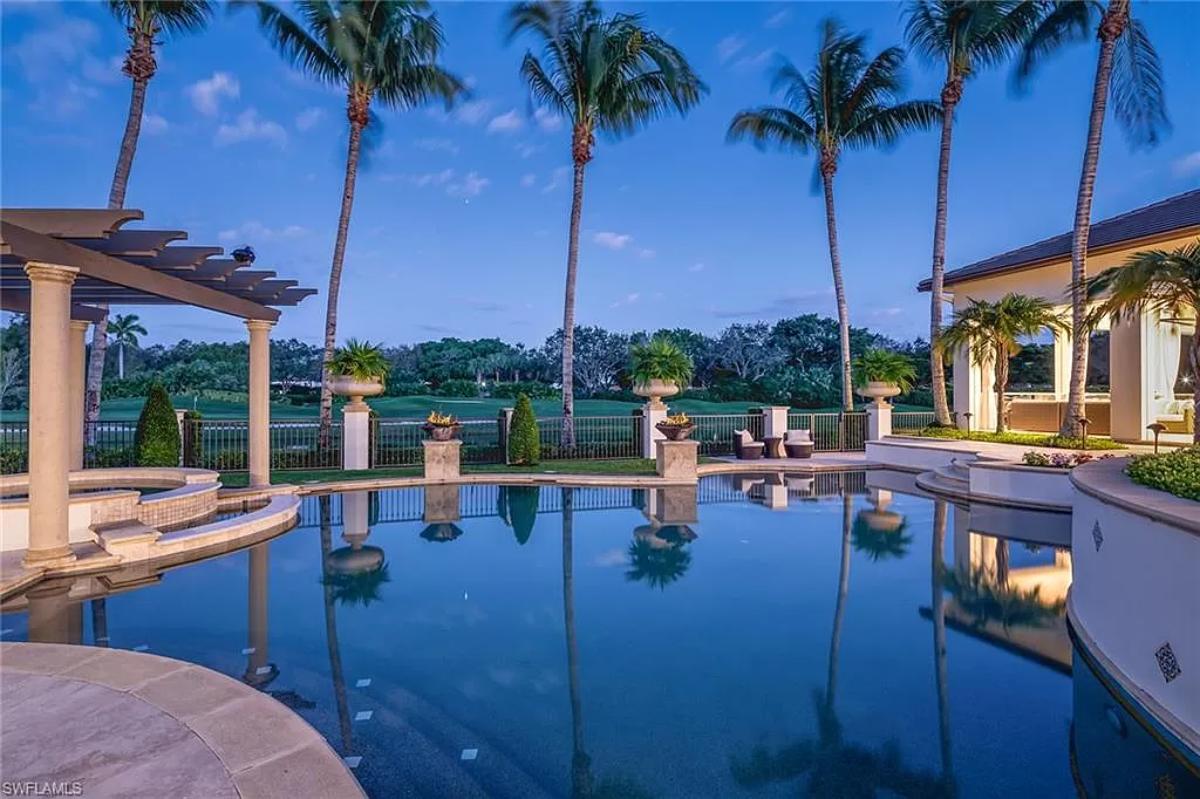 Pool with a jacuzzi and a pergola.