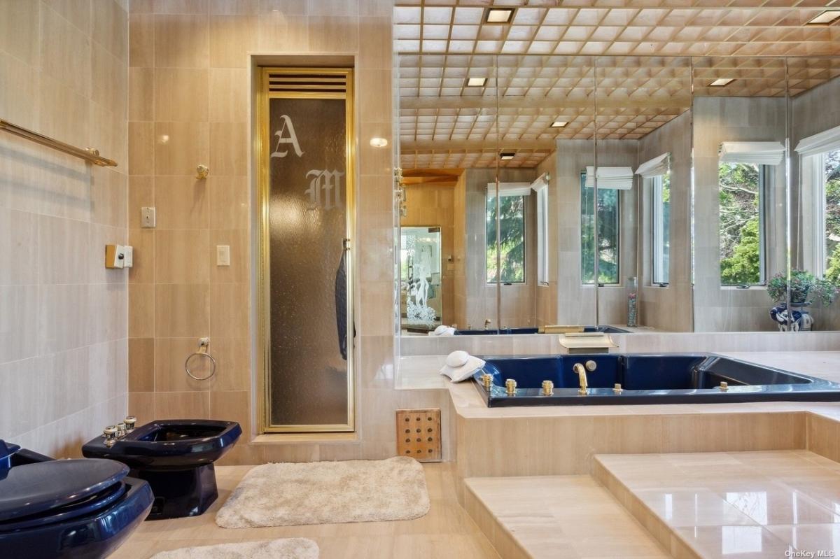 Bathroom with a soaking tub, walk-in shower and huge mirrors.