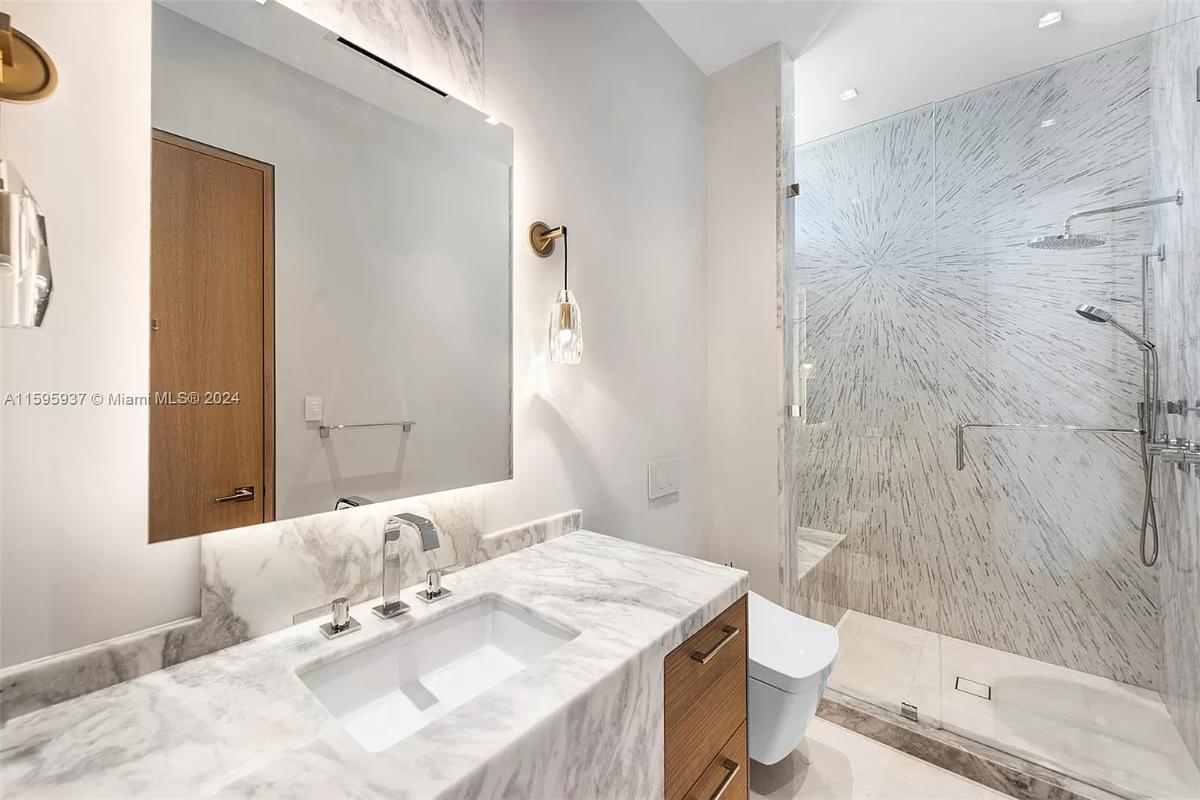 Bathroom with a sink, toilet and a walk-in shower.