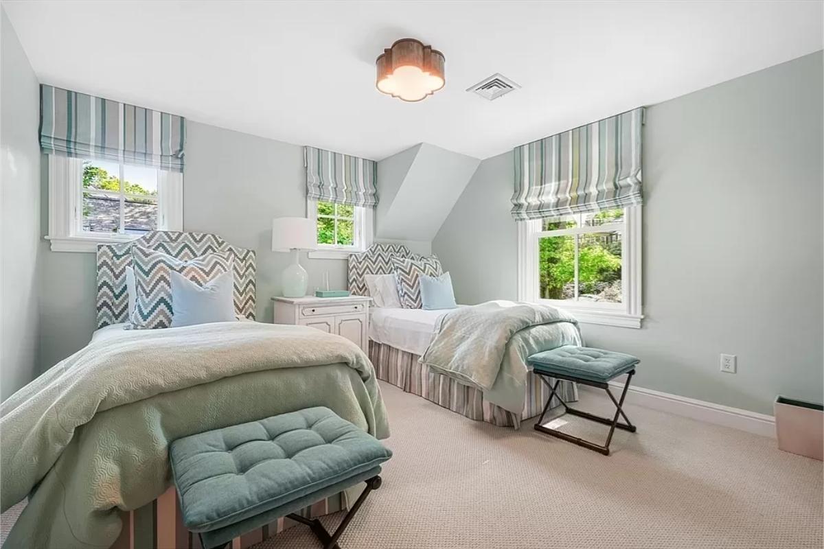 Bedroom with two beds and carpet flooring.