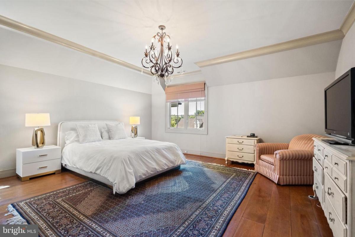 Bedroom with hardwood floors and custom lighting.