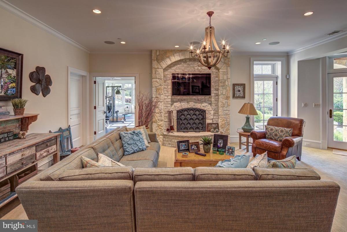 Family room with couches, chandelier and a fireplace.