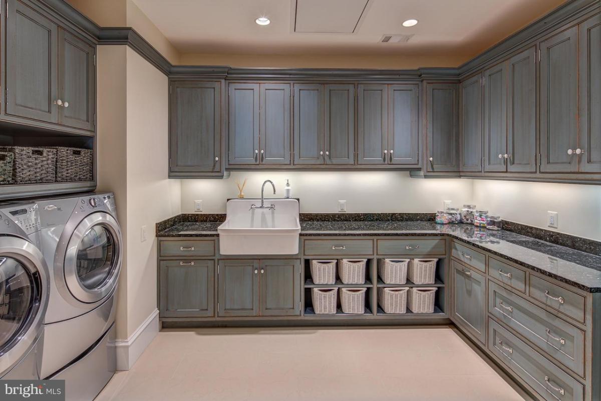 Laundry room with a sink and custom cabinetry.