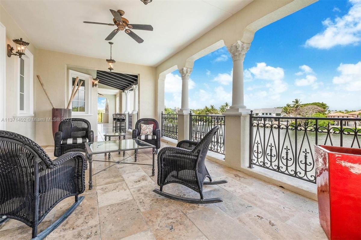 Balcony with a table and rocking chairs.