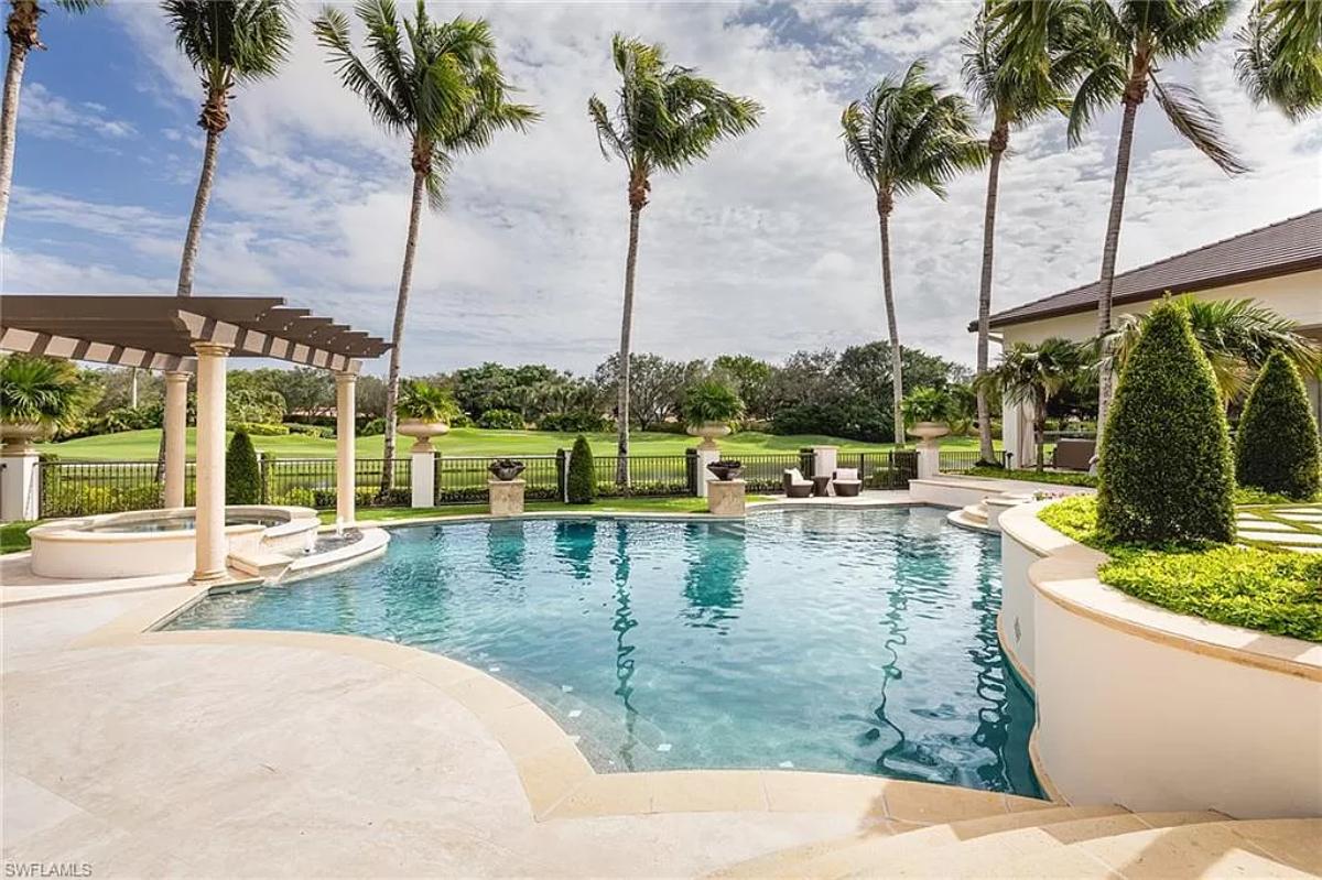 Pool with a jacuzzi and a pergola.