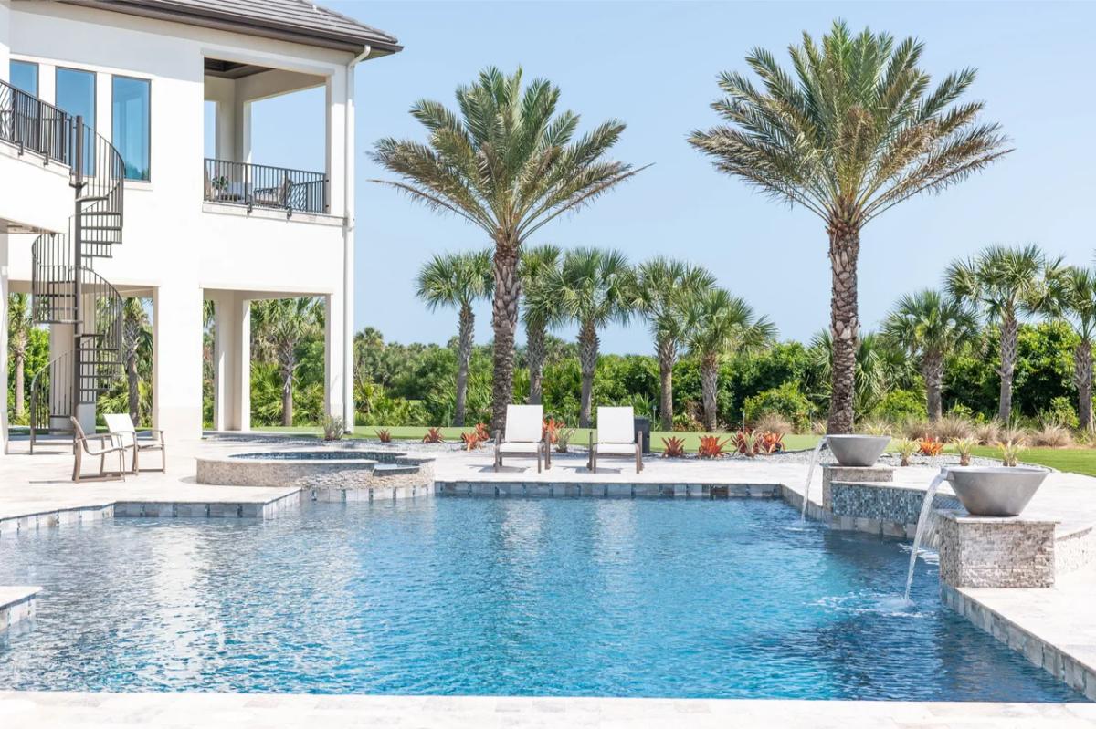 Pool with a jacuzzi and lounge chairs.