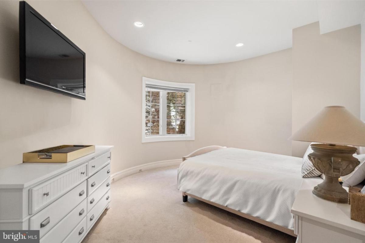 Bedroom with carpet flooring and a TV.