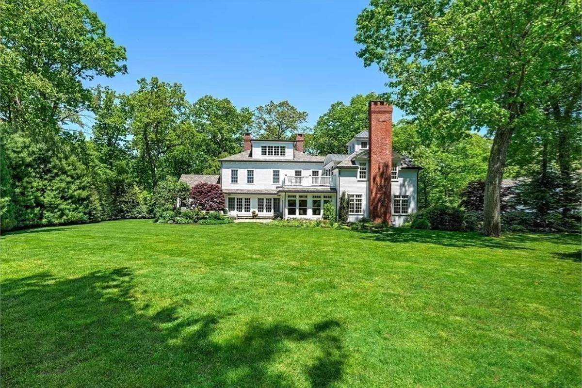 Rear view of the mansion with a huge green lawn.