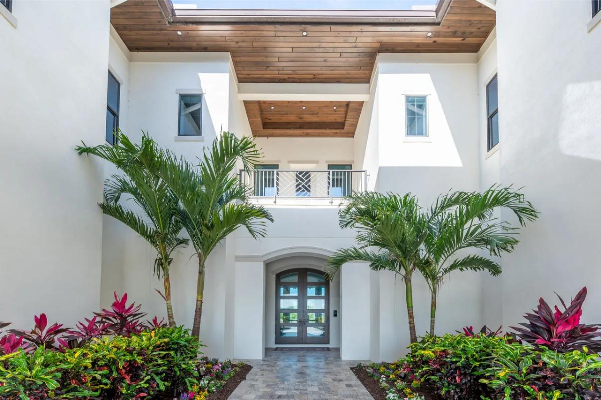 Front entry of the mansion with a walkway and plants.