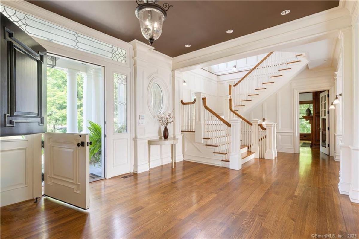 Foyer with hardwood floors and stairs.
