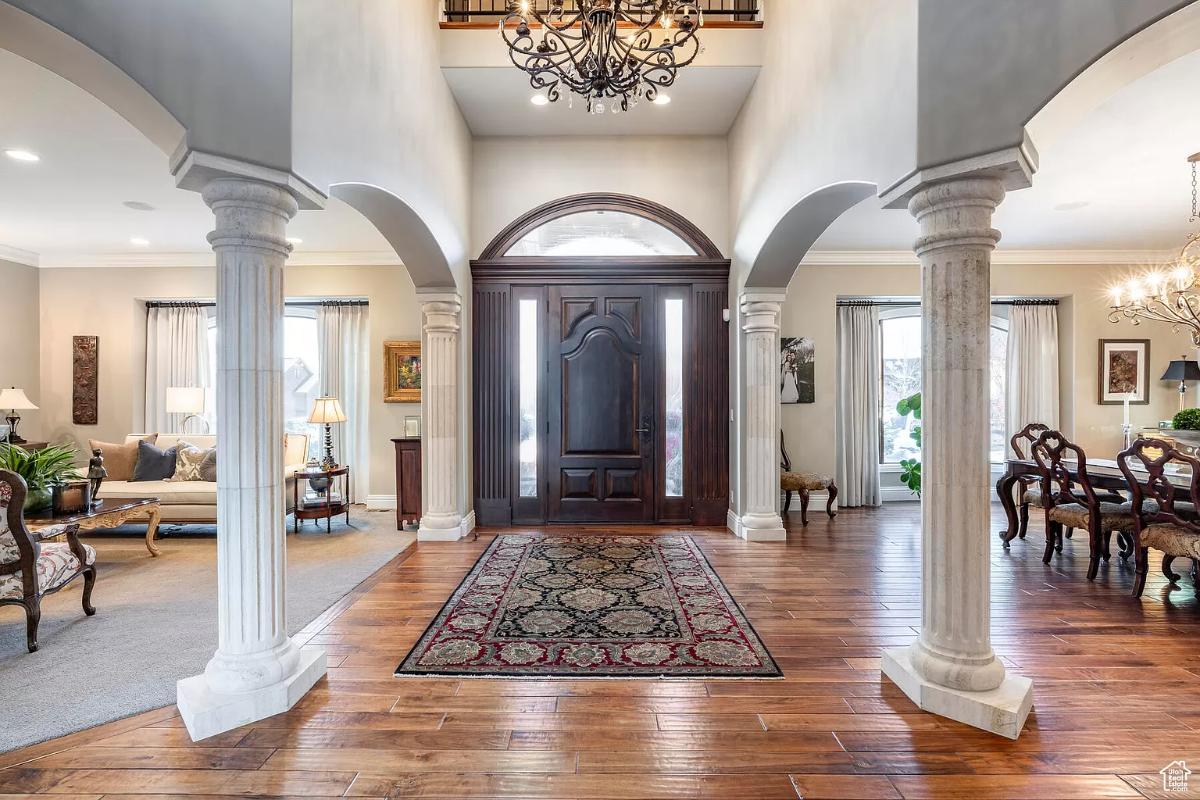 Foyer with a hardwood door and a chandelier.