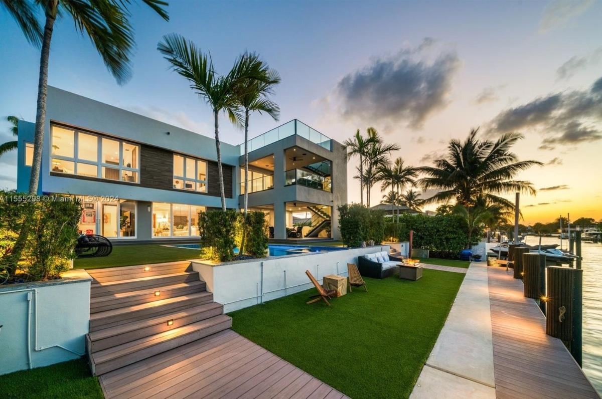 Rear view of the mansion with a pool and a boat dock.