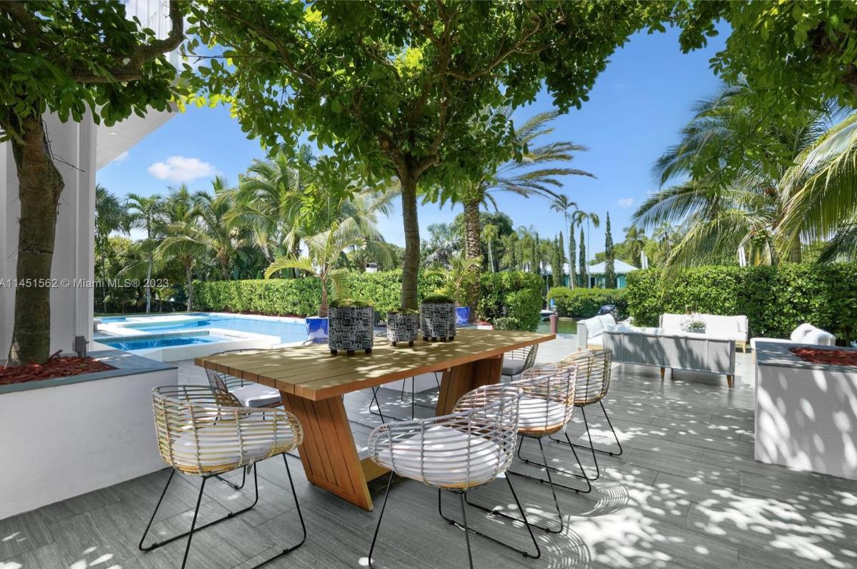 Patio on a deck with tables and chairs.