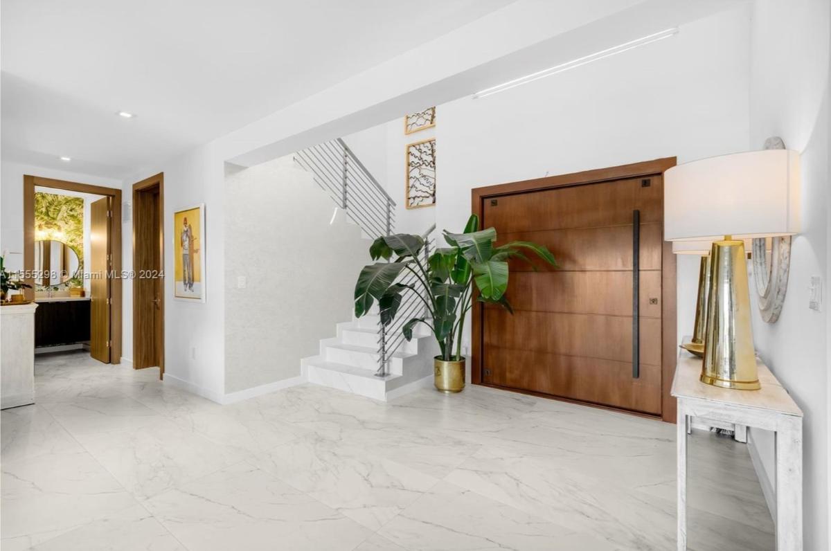Foyer with a huge wood door.
