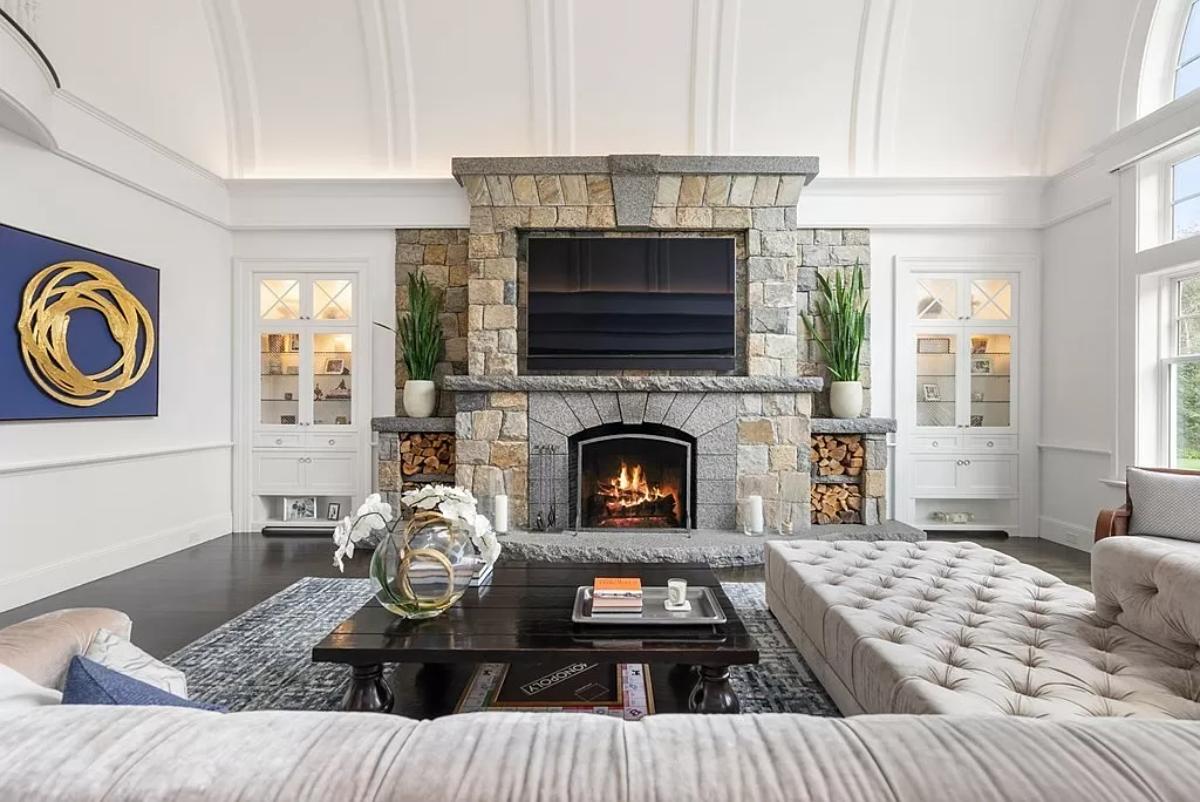 Living room with a fireplace, hardwood floors and couches.